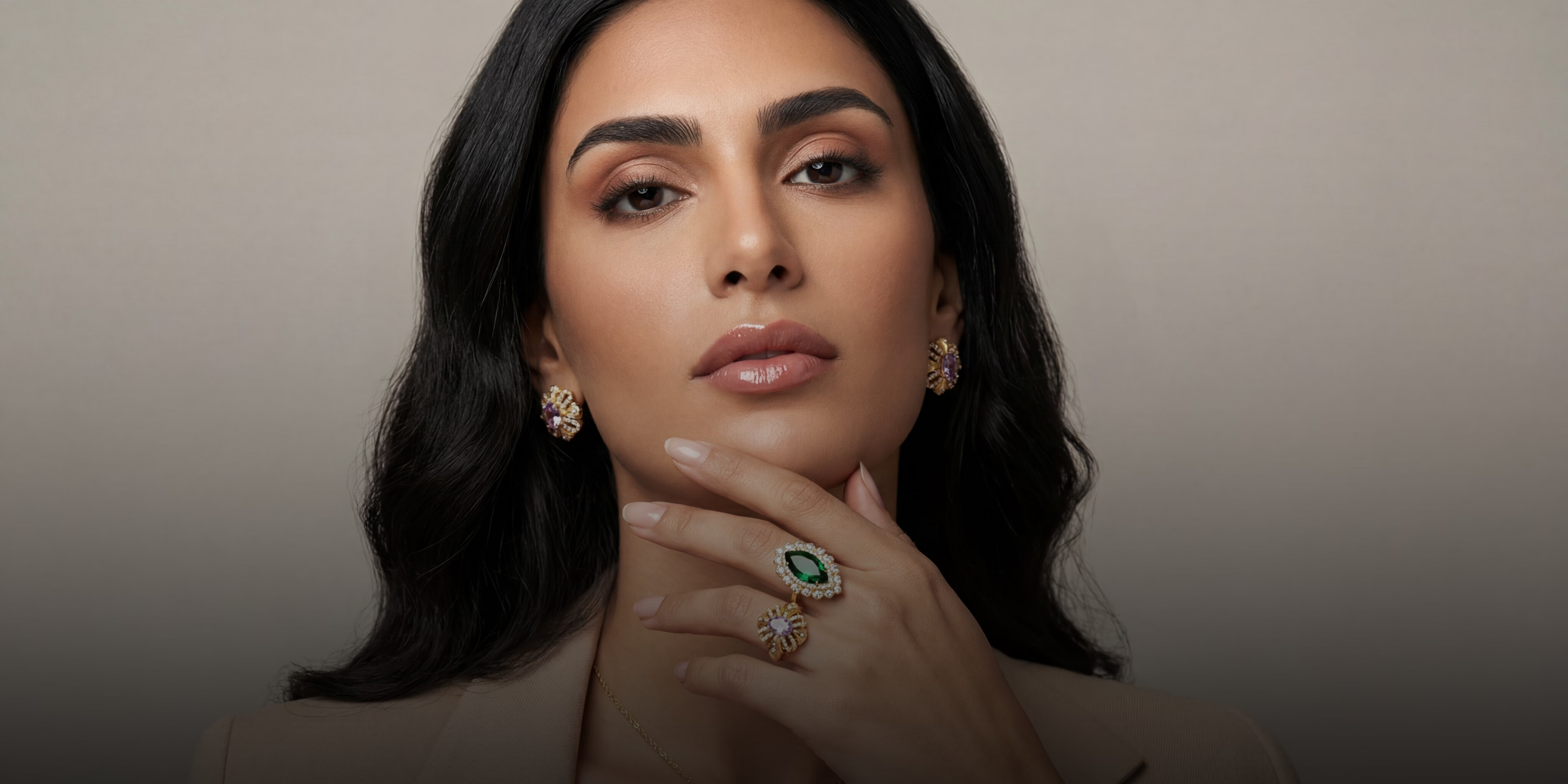 Woman wearing jewelry with a neutral background
